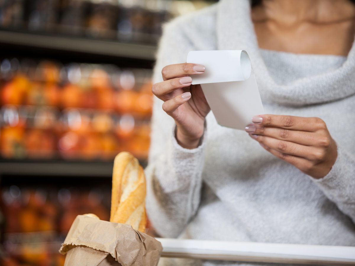 Shopper reading a package label in a supermarket aisle