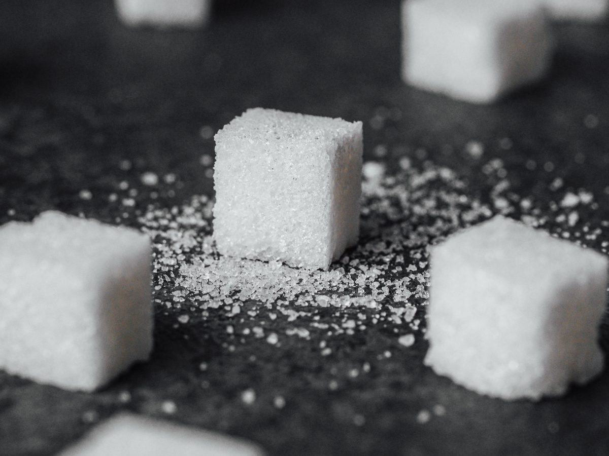 Sugar cubes scattered on a dark slate surface