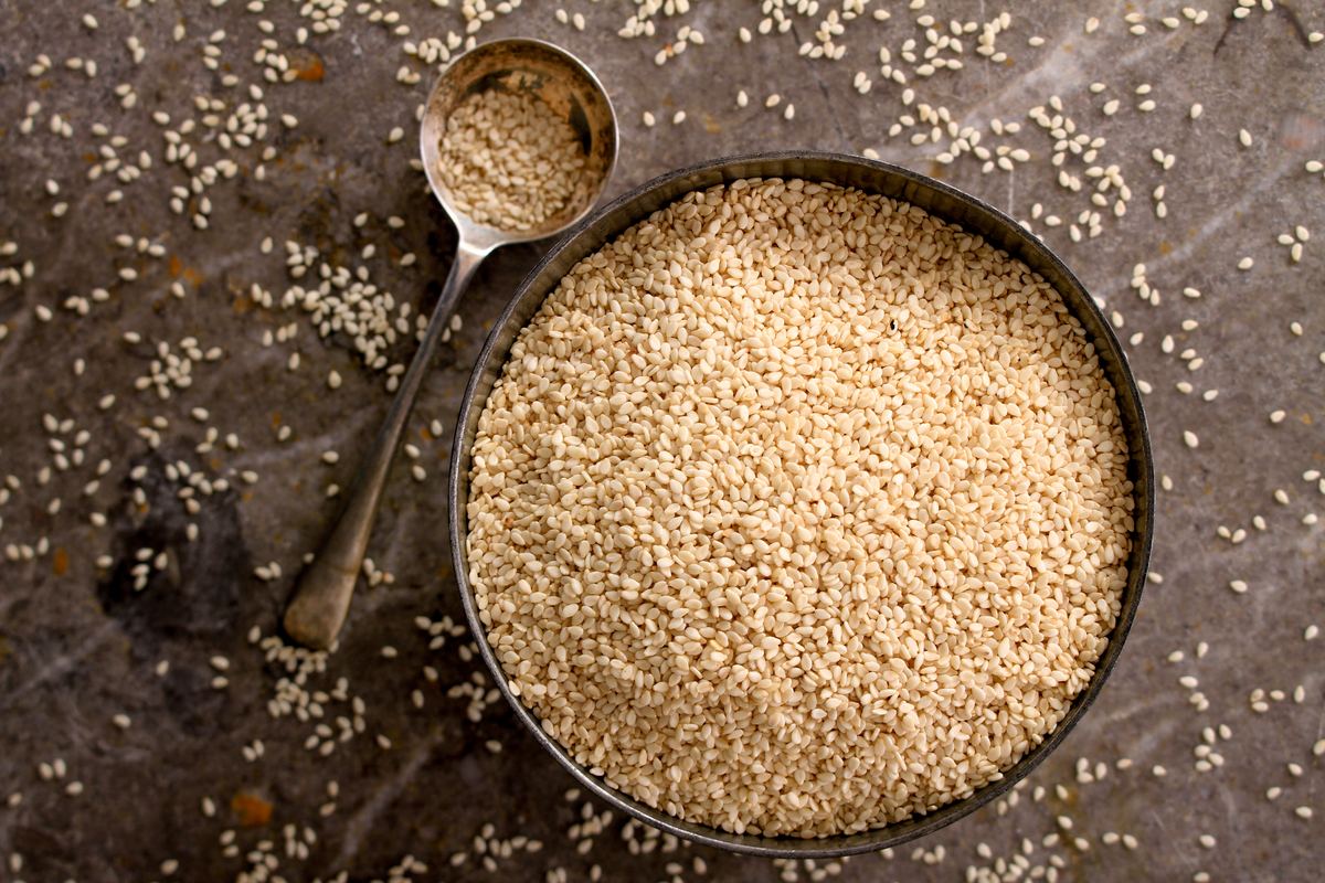 Bowl of sesame seeds with a spoon