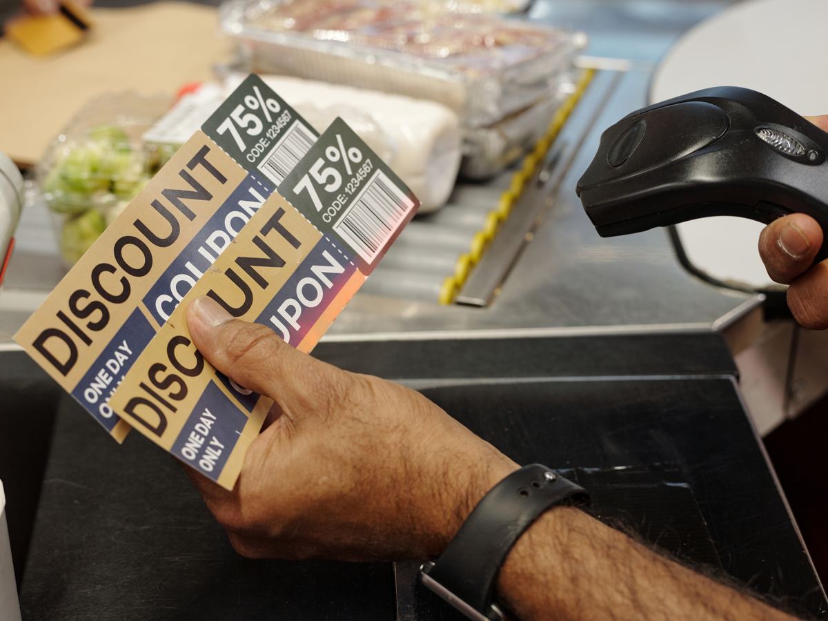Hand scanning a product barcode with a handheld scanner at checkout