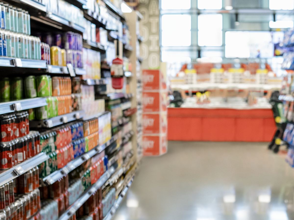 Grocery store aisle stocked with packaged beverages and goods