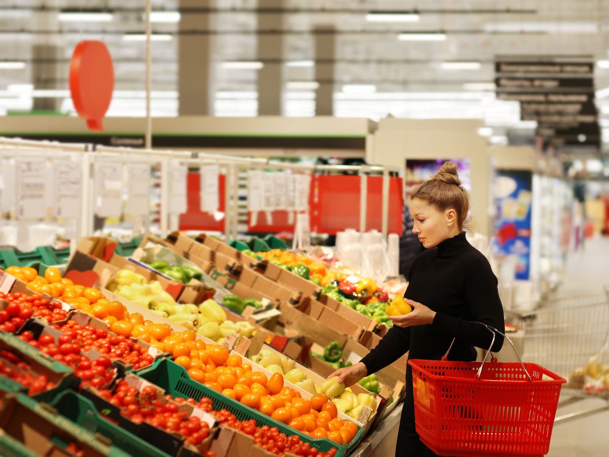 Shopper choosing fresh produce in a European supermarket