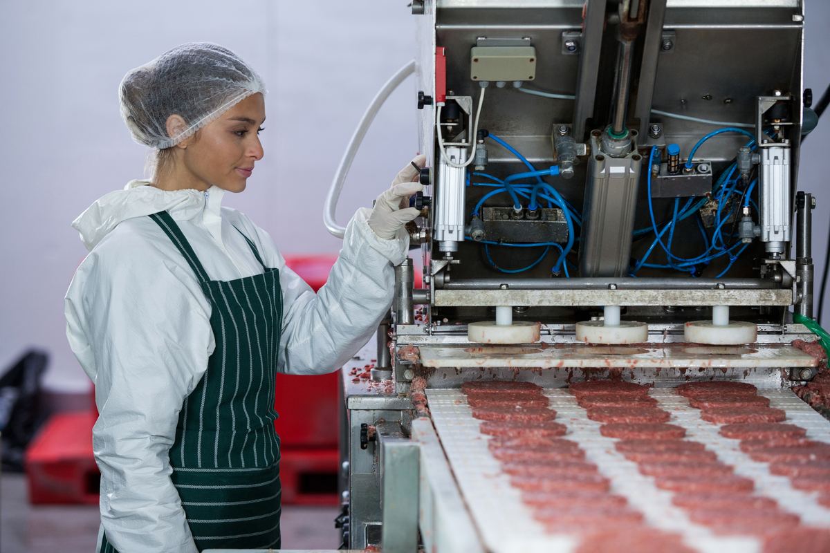 Worker operating a food processing line in a factory
