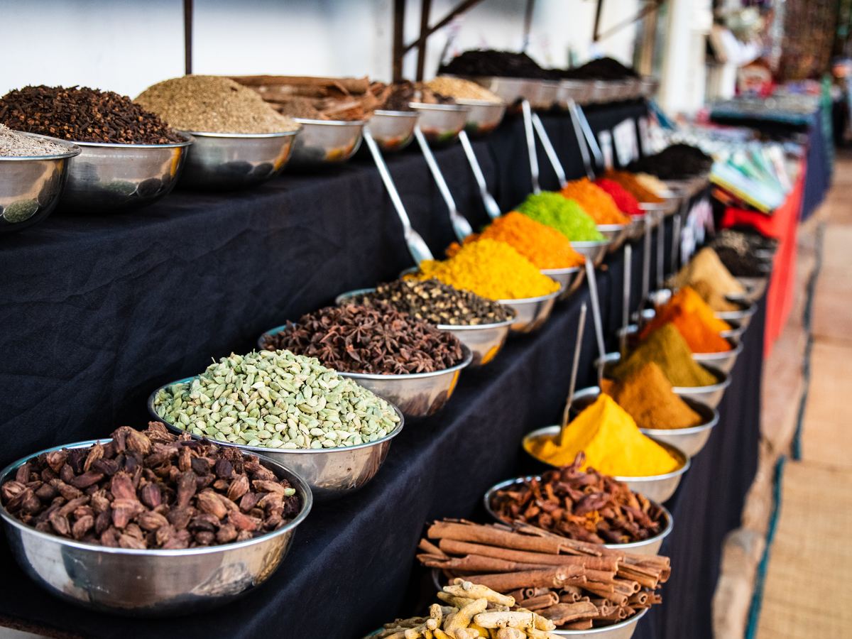 Bowls of colorful spices lined up at an Indian market stall