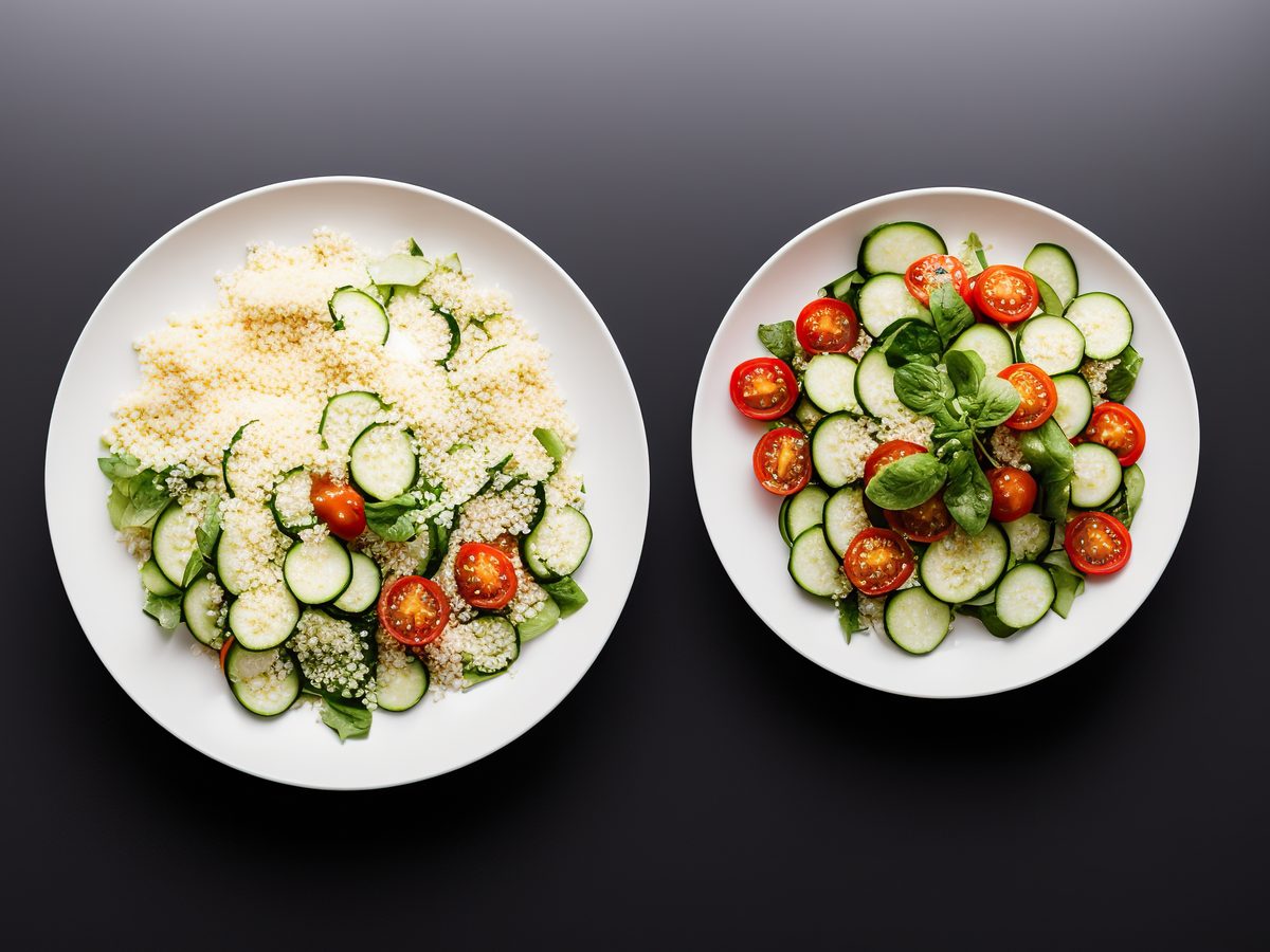 Two plates side by side, one heaped with couscous salad and one with salad only